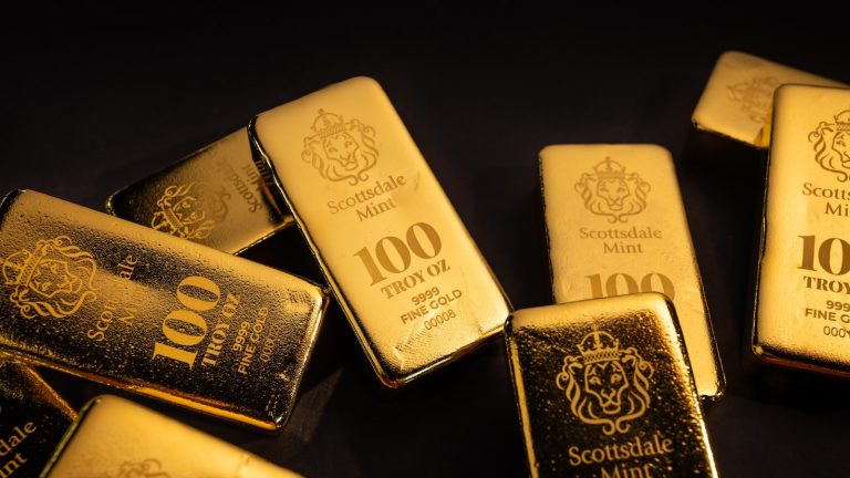 Mehrere Goldbarren auf dunklem Untergrund, Symbolbild Goldanbieter Vergleich